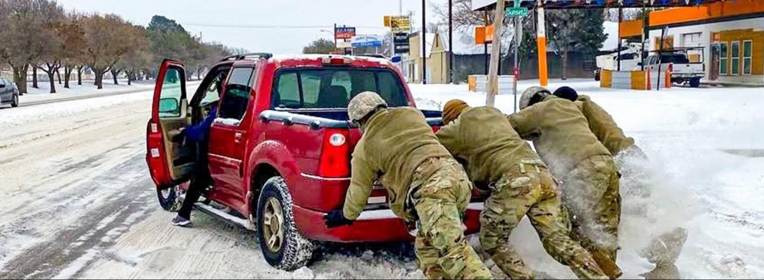 Texas Army Nation Guardsmen assist a motorist stuck on snow and ice