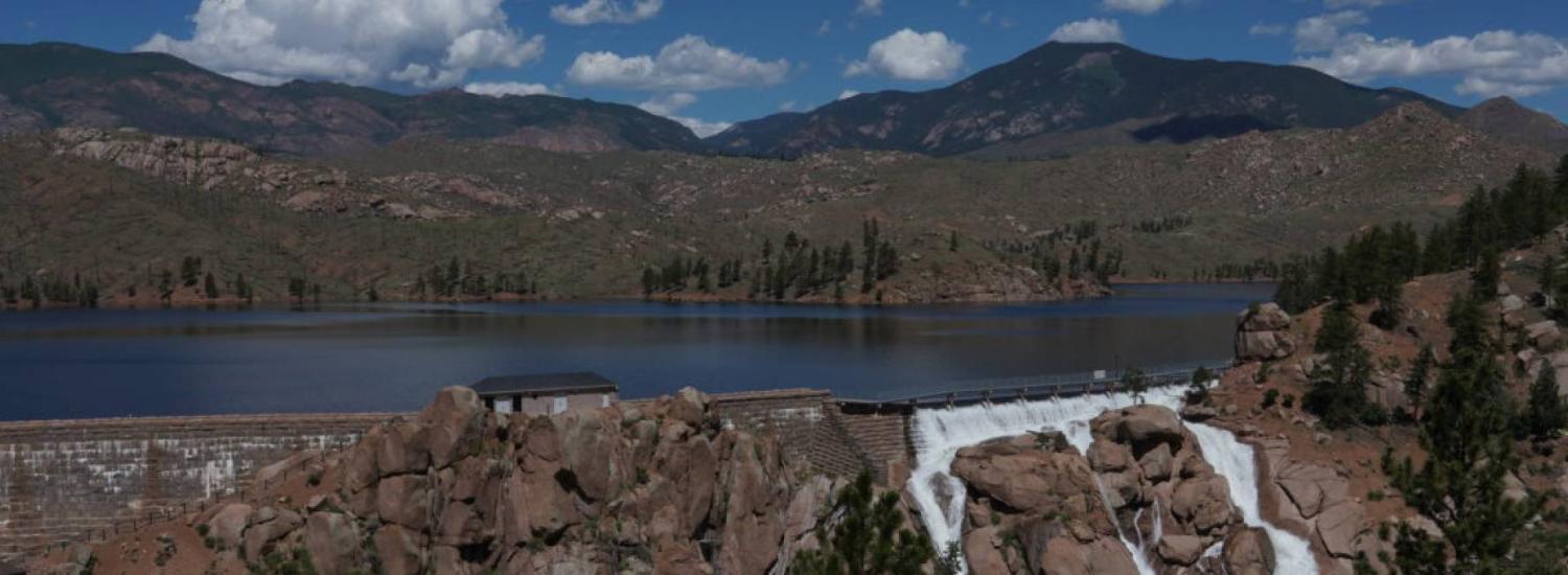 Cheesman Dam spills water down its spillway, a 220-foot high wall of boulders, in June 2019.