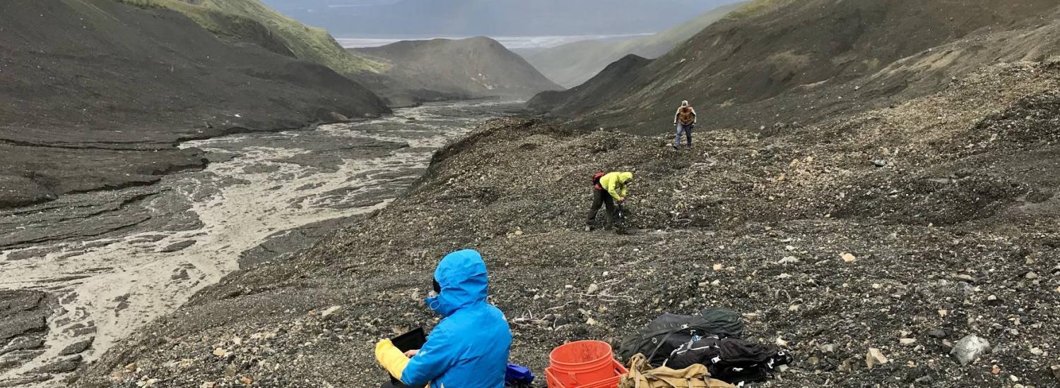 Researchers take measurements in a rocky glacier setting