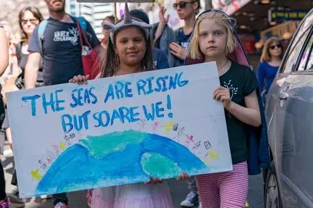 Image of girls holding climate sign.