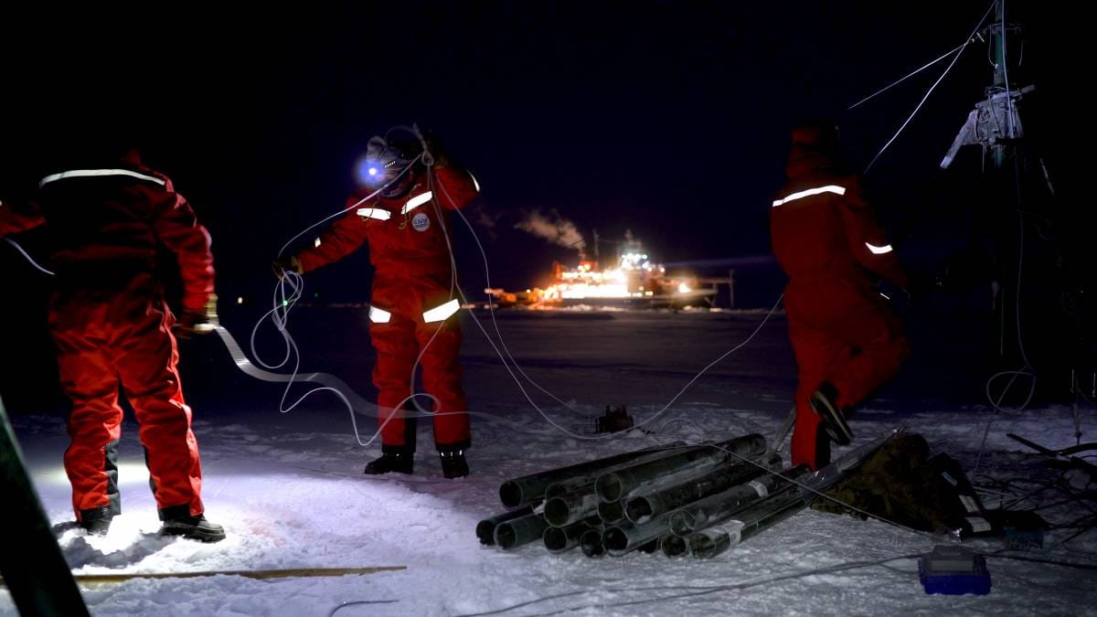 Researchers prepare to stabilize a small ice-based tower.