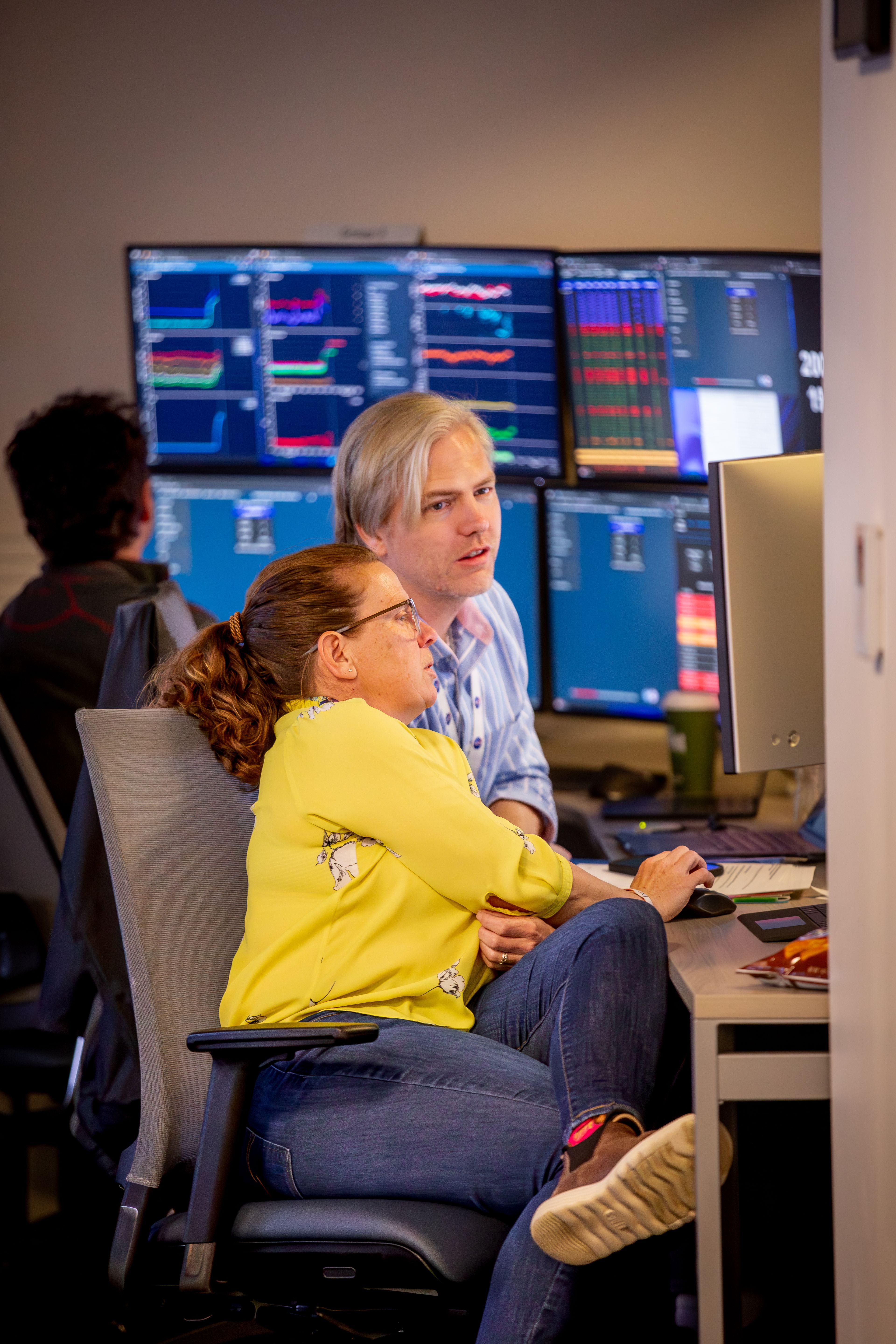 Two participants pour over screens and forecasts during the Space Weather exercise. 