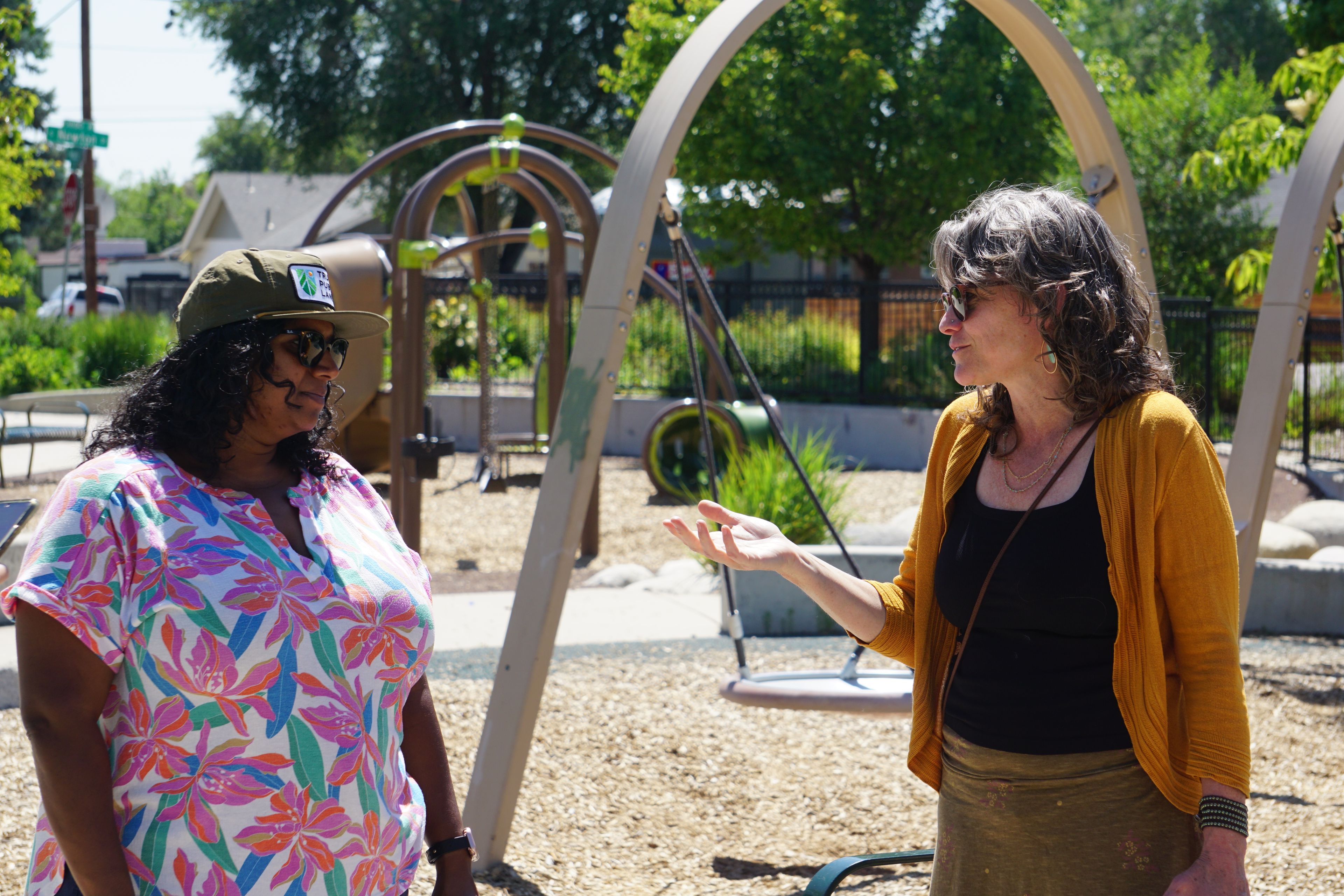Two people talk at a Denver park about supporting communities