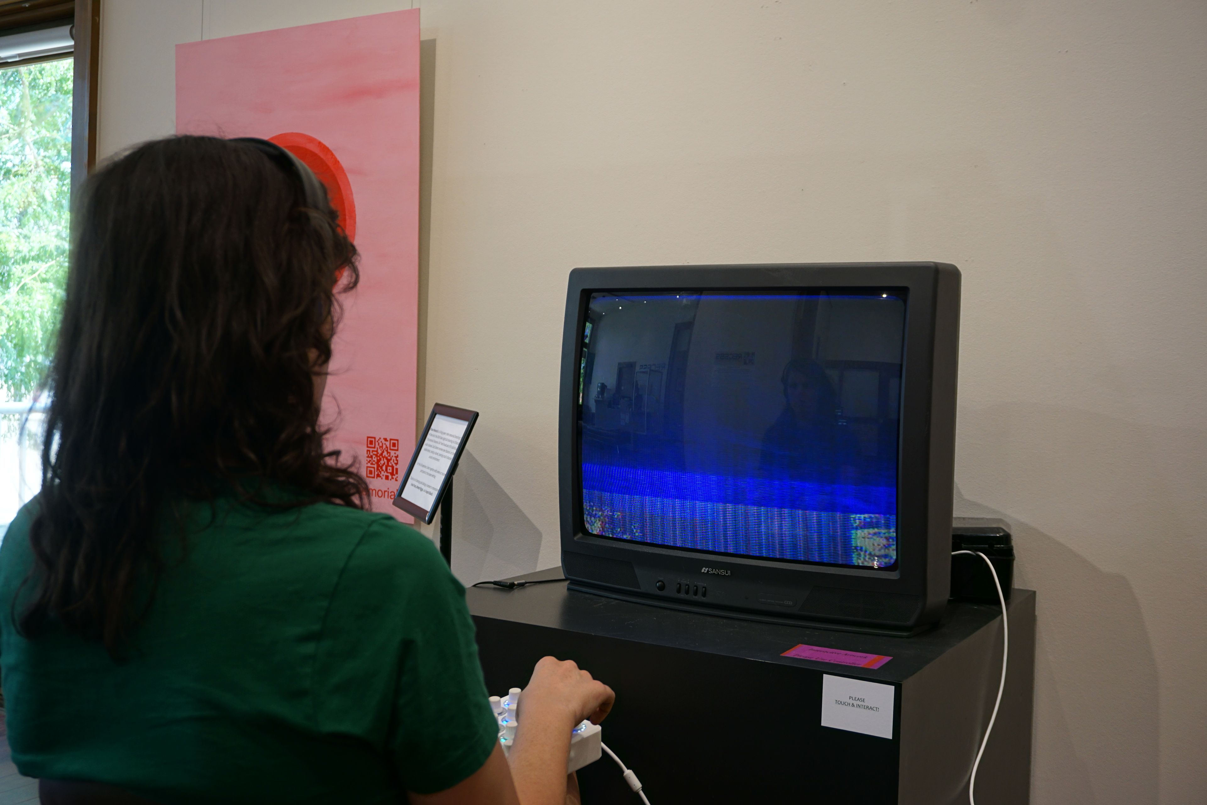 Student researcher Leah Bertrand interacts with the art exhibit they developed