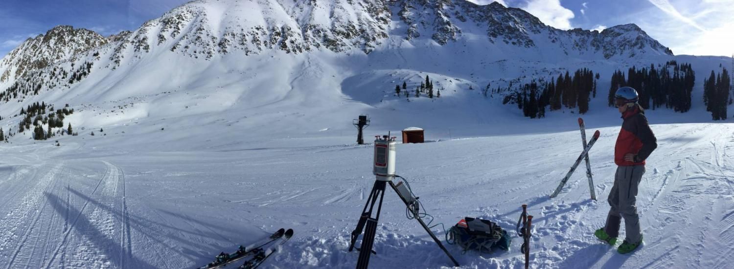 Person in snow-covered valley with research equipment