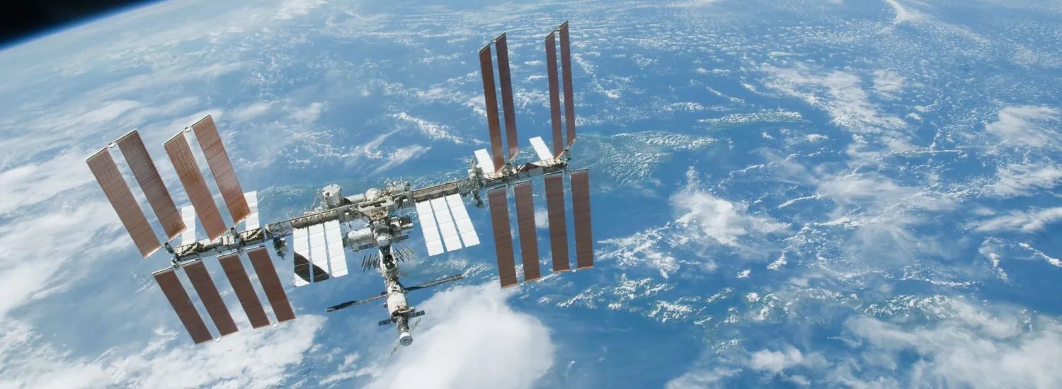 blue/white earth in background, metal gray space station in foreground