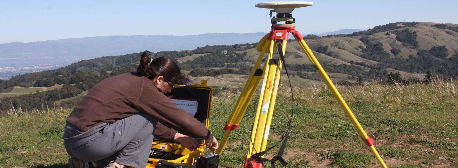 a researcher does fieldwork on a hill above a winery