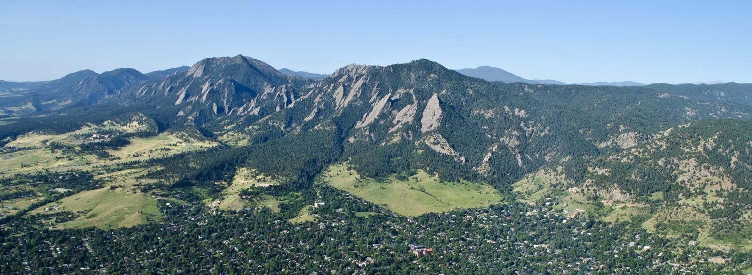 Mountains, trees, grasses, and buildings from aerial point of view