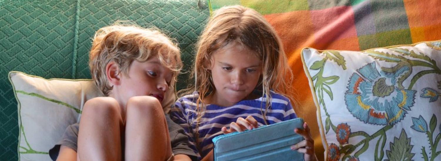 kids on a couch using ipad
