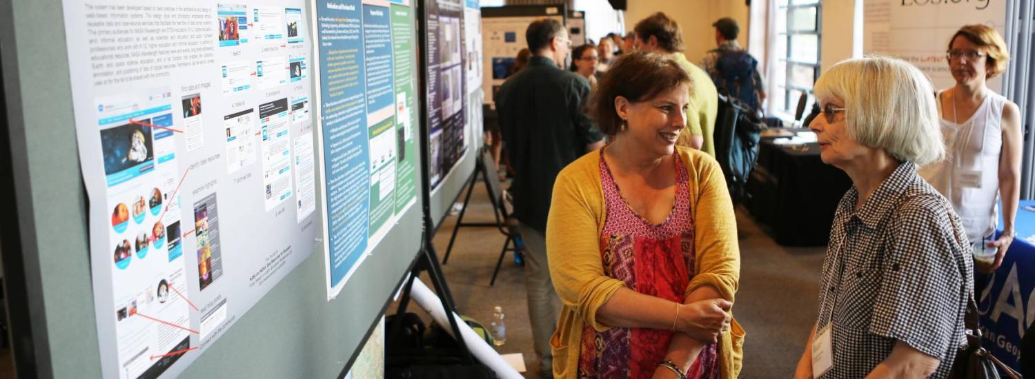 two women talking at a science poster