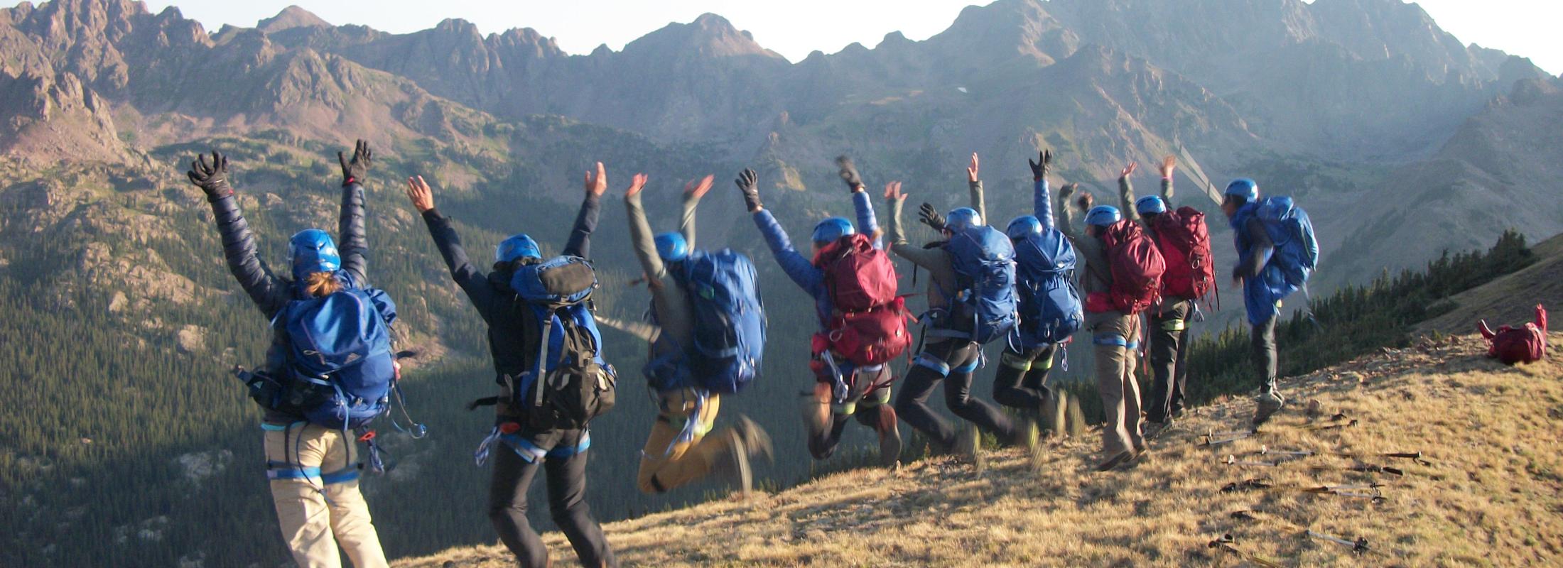 Backpacking participants jumping