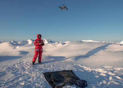 A scientist flies a drone over the arctic sea ice.