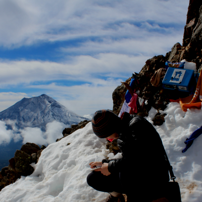 Researcher writing on a mountain side 