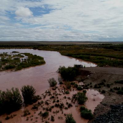 Flooding plains covered in green vegetation and red, clay stained water