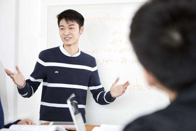 A student stands while doing a presentation.